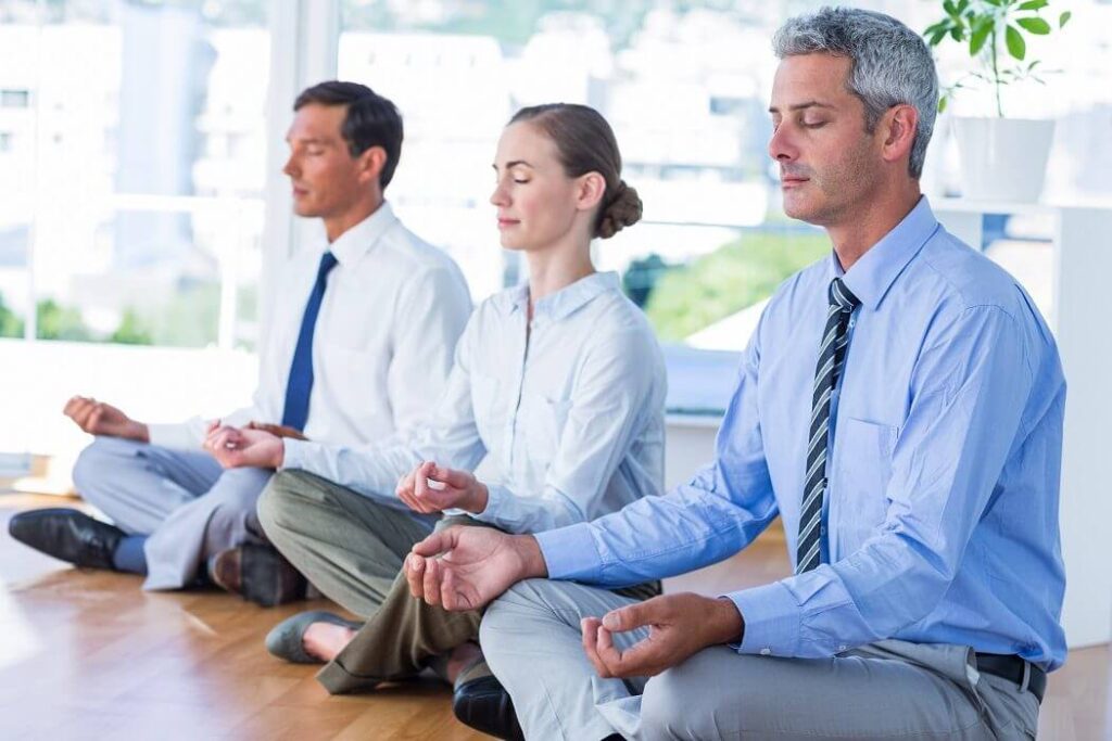 Grupo de profesionales haciendo mindfulness en el trabajo